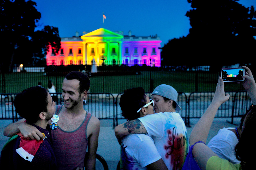 WASHINGTON, DC- JUNE 26: With at colorful White House backdrop, (L) Kevin Barragan and his partner Adam Smith celebrate the decision today as do Kelly Miller (with glasses) and her wife Lindsey Miller. The Miller's were married 2 years ago in Washington State where gay marriage was legal.The White House was lit in multi-colored lights tonight to honor the Supreme Court decision to allow gay marriage. Michael S. Williamson/The Washington Post via Getty Images)