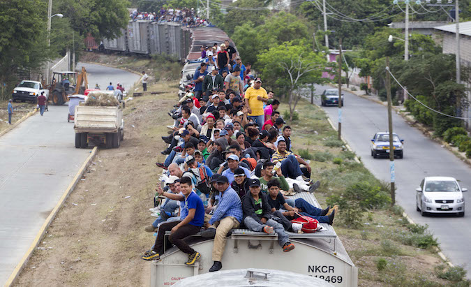 Migrants ride on top of a northern bound train toward the US-Mexico border in Juchitan, southern Mexico, Monday, April 29, 2013. Migrants crossing Mexico to get to the U.S. have increasingly become targets of criminal gangs who kidnap them to obtain ransom money. (AP Photo/Eduardo Verdugo)